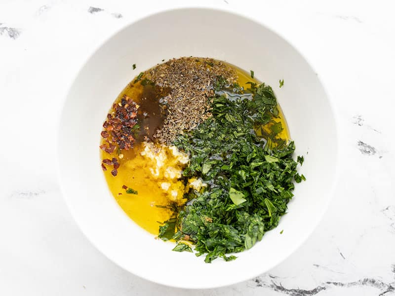 Chimichurri ingredients in a bowl, not stirred