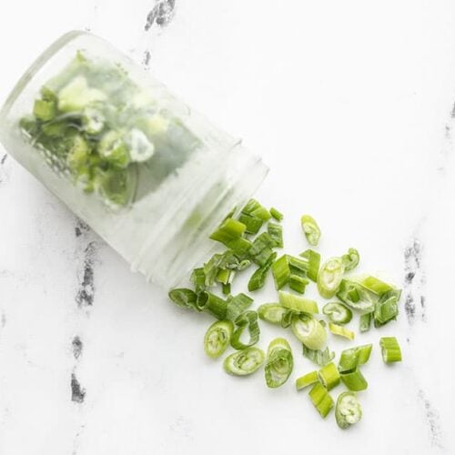 Frozen sliced green onion pouring out of a mason jar