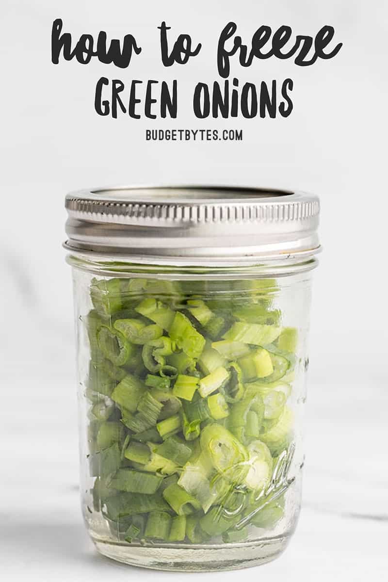 Fresh sliced green onions in a mason jar with title text at the top
