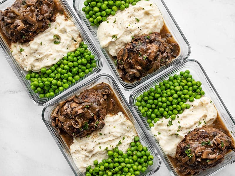 Salisbury Steak in rectangular meal prep containers with mashed potatoes and peas