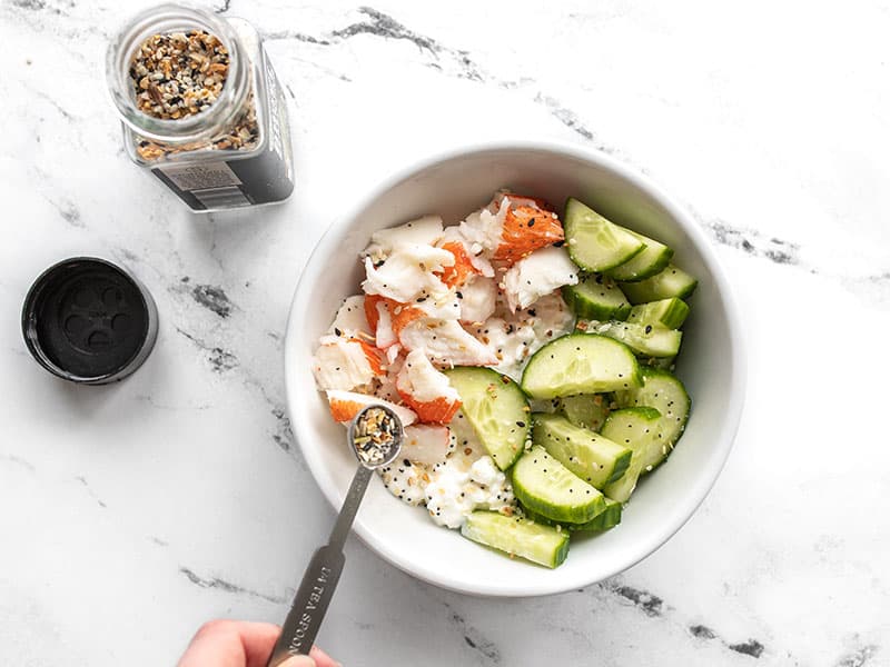 Adding everything bagel seasoning to the crab bowl