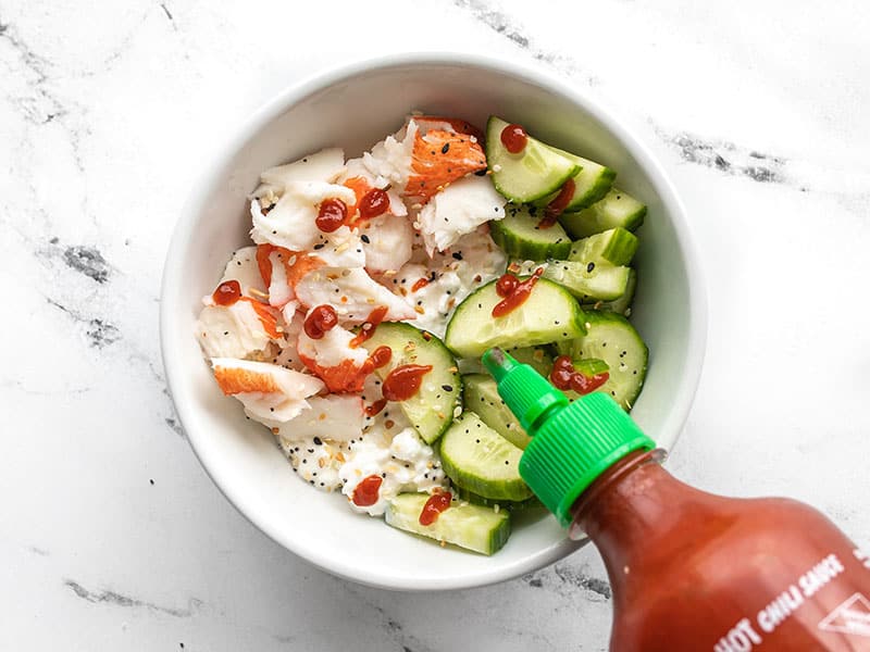 cottage cheese crab bowl being drizzled with sriracha