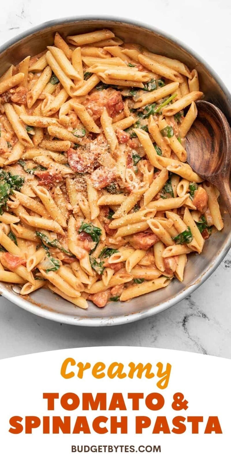 creamy tomato spinach pasta in a skillet, title text at the bottom