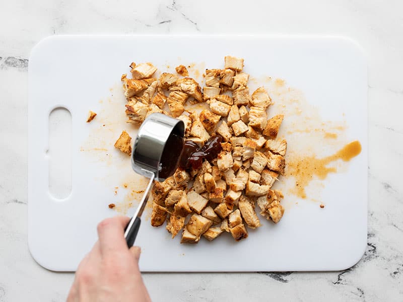 BBQ Sauce being added to chopped chicken