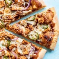 Close up of one slice of BBQ Chicken Pizza being pulled away from the pie