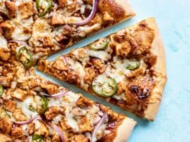 Close up of one slice of BBQ Chicken Pizza being pulled away from the pie