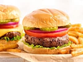 Side view of a black bean burger in a hamburger bun with toppings.