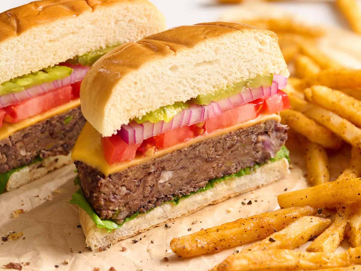 A black bean burger sliced in half in a burger bun.