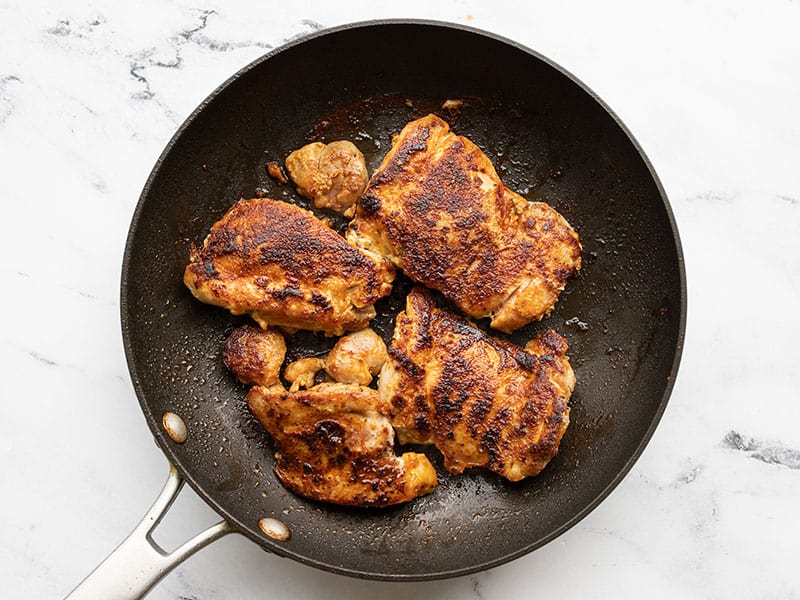 Cooked chicken thighs in a skillet