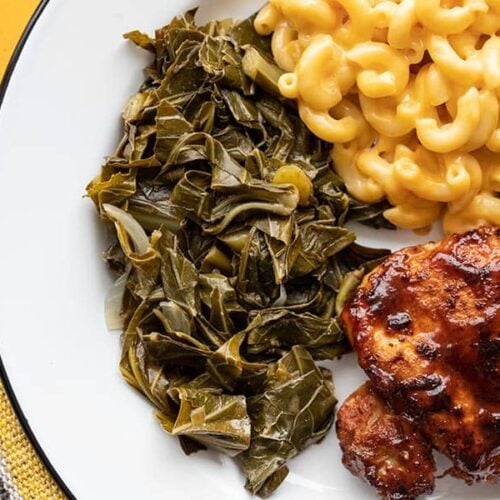 jerk seasoned collard greens on a plate with mac and cheese and bbq chicken