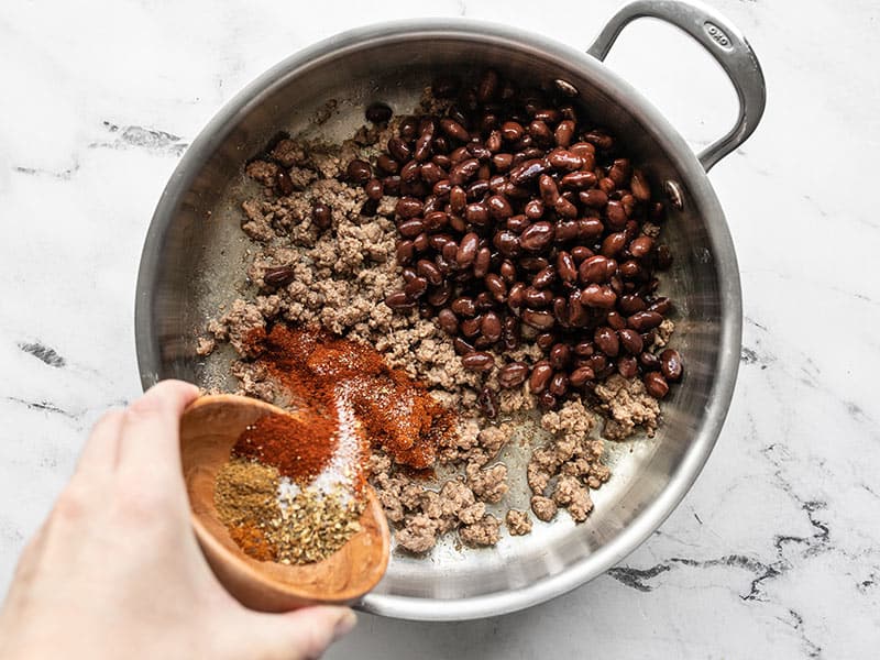 black beans and taco seasoning added to the skillet