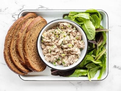 Classic tuna salad in a bowl with bread and lettuce on the sides