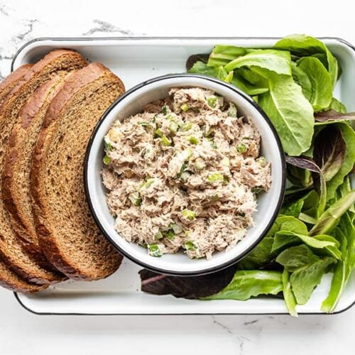 Classic tuna salad in a bowl with bread and lettuce on the sides