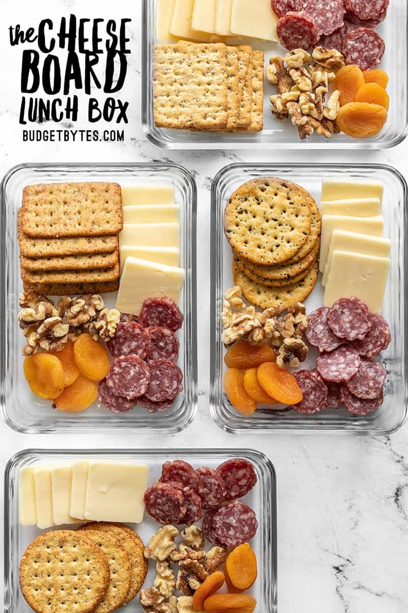 Four staggered cheese board lunch boxes with title text at the top