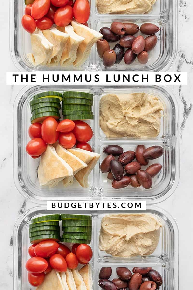Three glass meal prep containers with hummus lunch box ingredients lined up in a row
