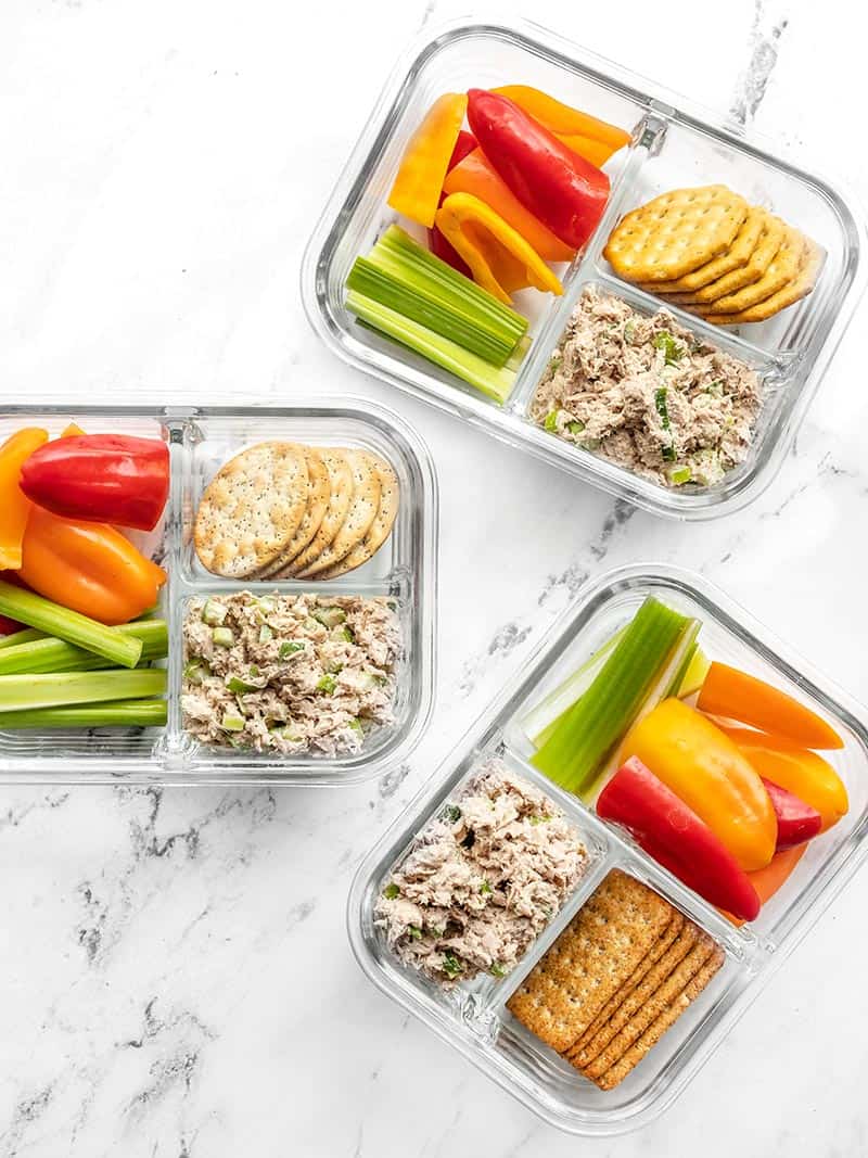 Three glass containers of the tuna salad lunch box scattered