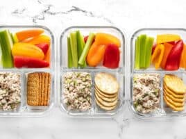 Three glass containers full of the tuna salad lunch box lined up in a row