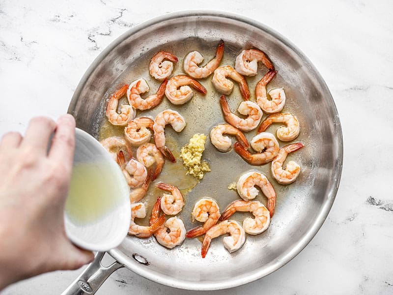 Garlic and lemon juice being added to the skillet