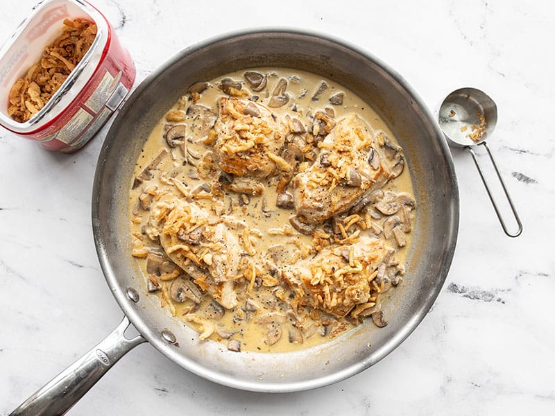 Creamy mushroom chicken in the skillet, topped with crispy fried onions