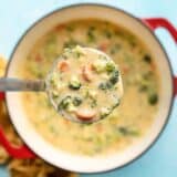 CLose up of a ladle full of broccoli cheddar soup