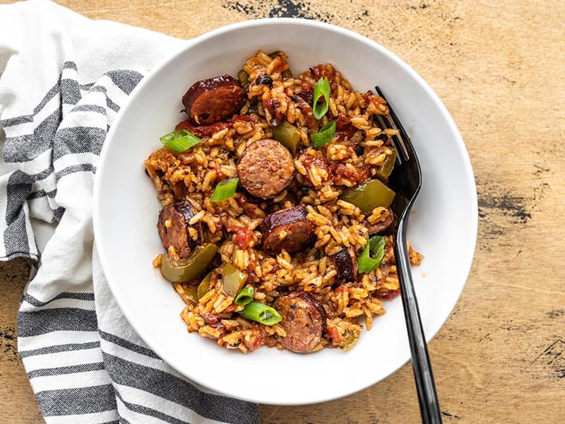 Overhead view of a bowl full of Cajun Sausage and Rice with a black fork in the side