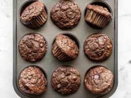 Chocolate Banana Muffins in a muffin tin, some turned on their side
