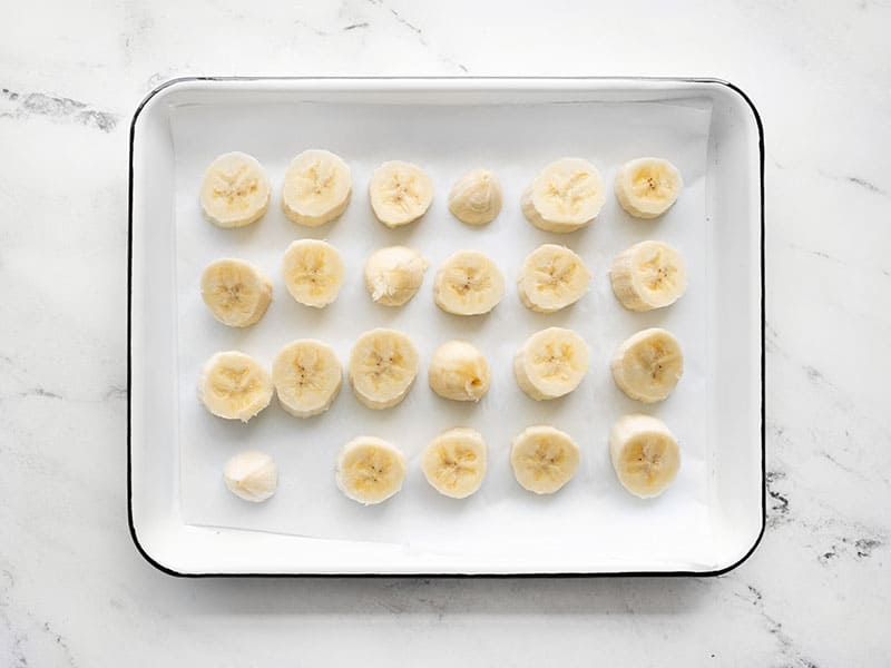 banana slices on a parchment lined baking sheet