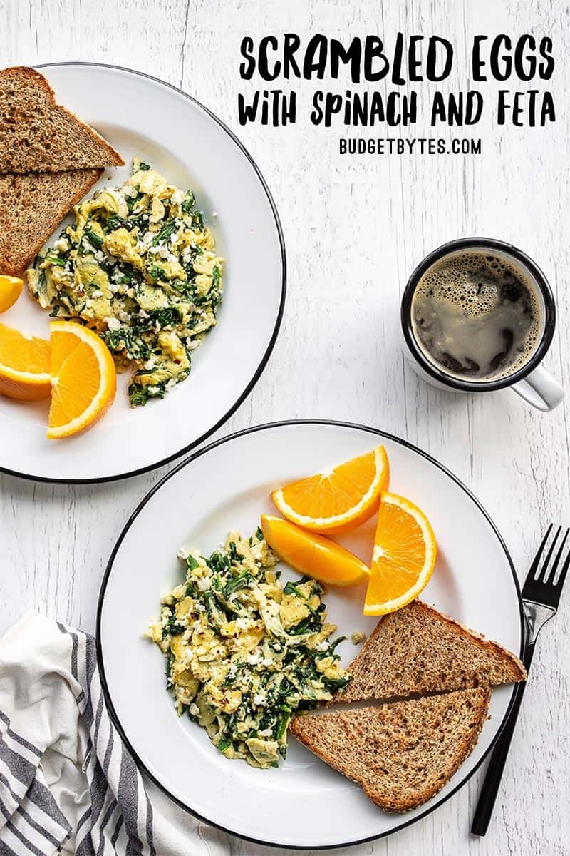 Two plates with scrambled eggs with spinach and feta, toast, and orange slices, title text at the top
