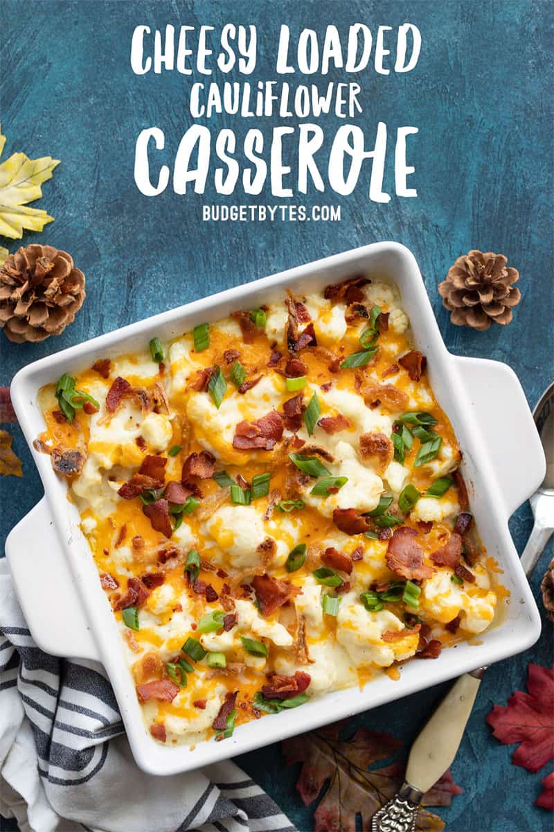 Overhead view of cheesy loaded cauliflower casserole with title text at the top
