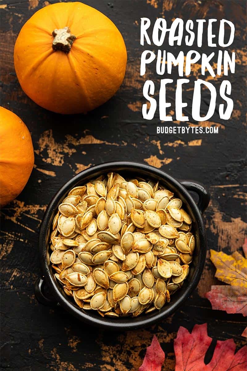 Roasted pumpkin seeds in a black ceramic bowl with title text at the top