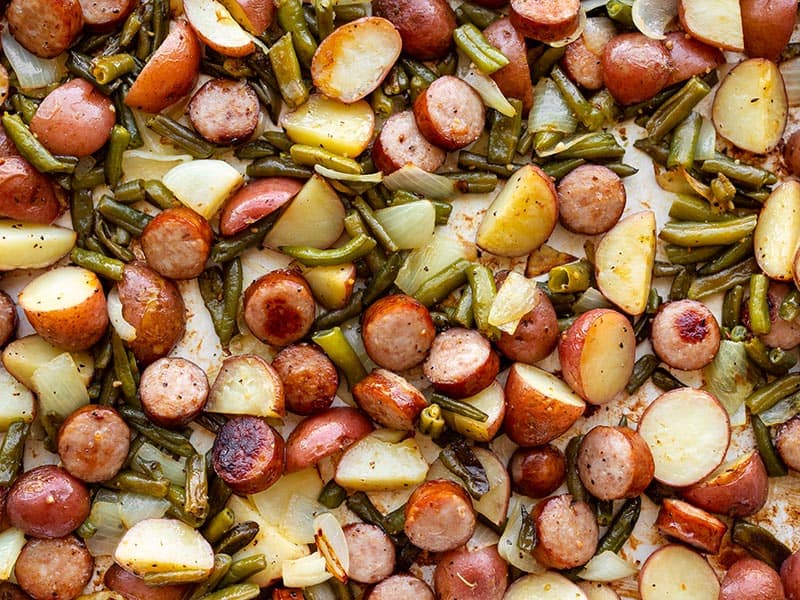 Close up of sheet pan kielbasa potatoes and green beans on a sheet pan