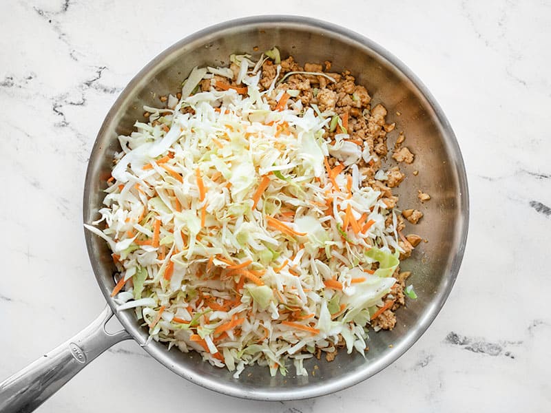 shredded cabbage and carrots added to the skillet