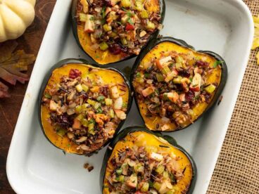 Wild rice stuffed acorn squash in a white casserole dish from above