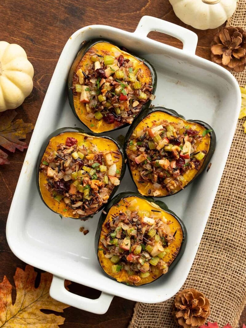 Wild rice stuffed acorn squash in a white casserole dish from above