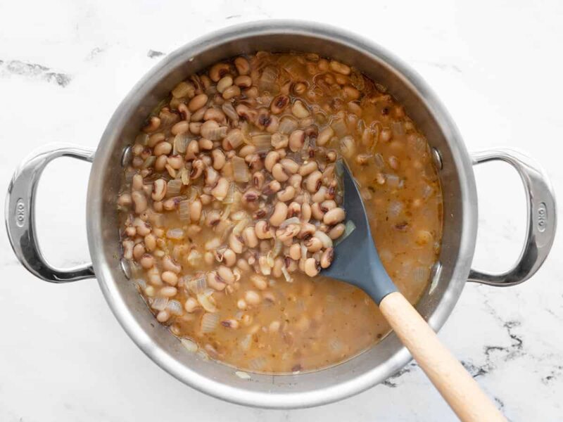 Simmered black eyed peas in the pot with a spoon
