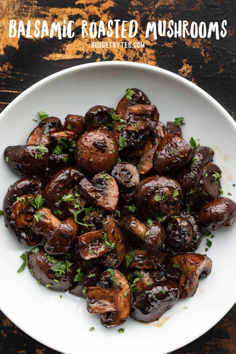 Overhead view of a bowl full of balsamic roasted mushrooms with title text at the top