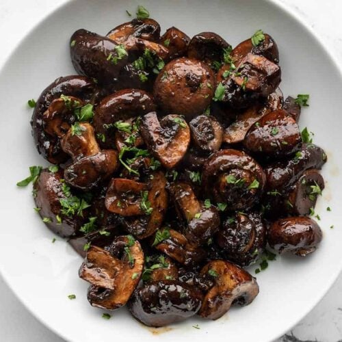 Overhead view of balsamic roasted mushrooms in a white bowl