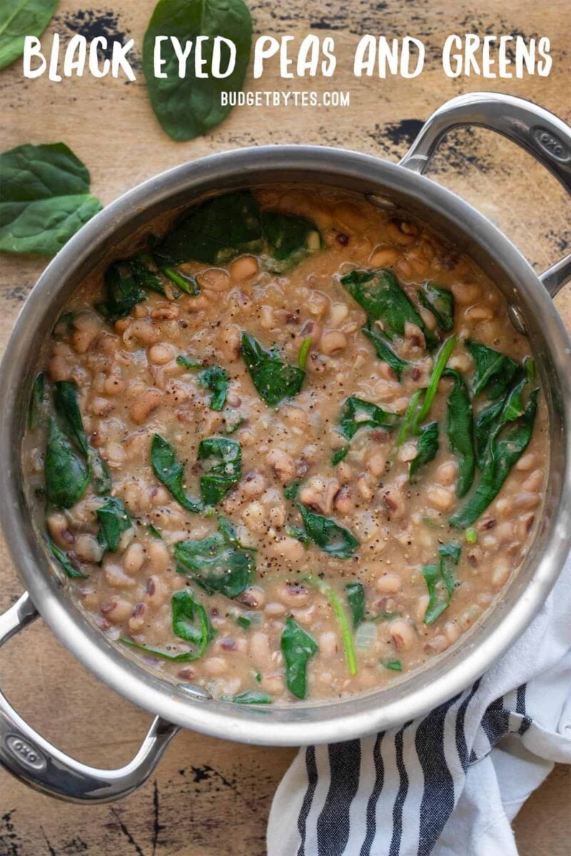 Overhead view of a pot full of black eyed peas and greens with title text at the top