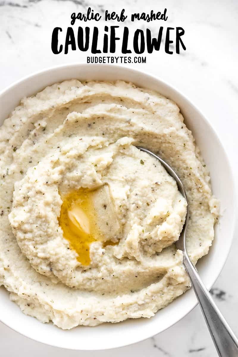 Mashed cauliflower in a bowl with a spoon and melted butter, title text at the top