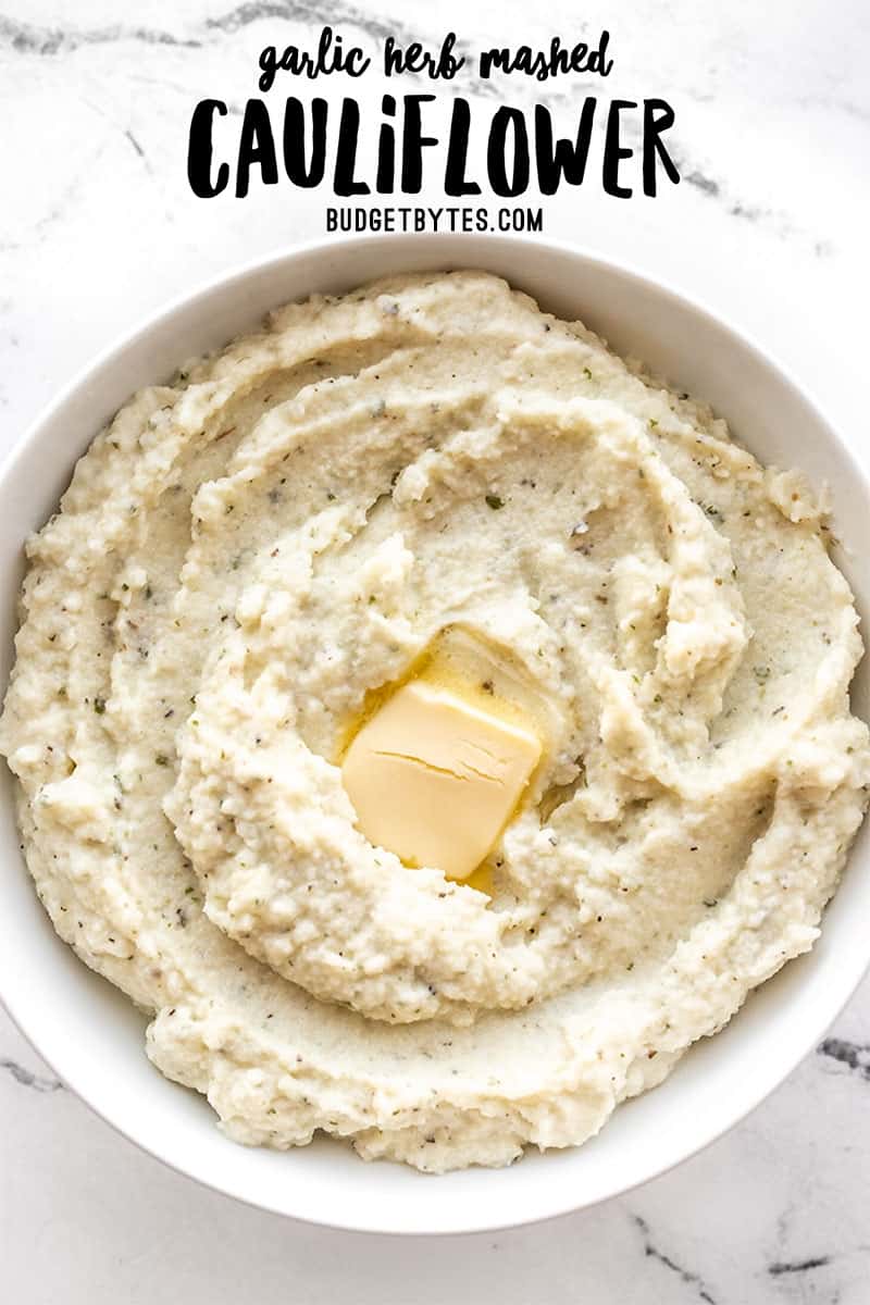Garlic herb mashed cauliflower in a bowl with butter, title text at the top