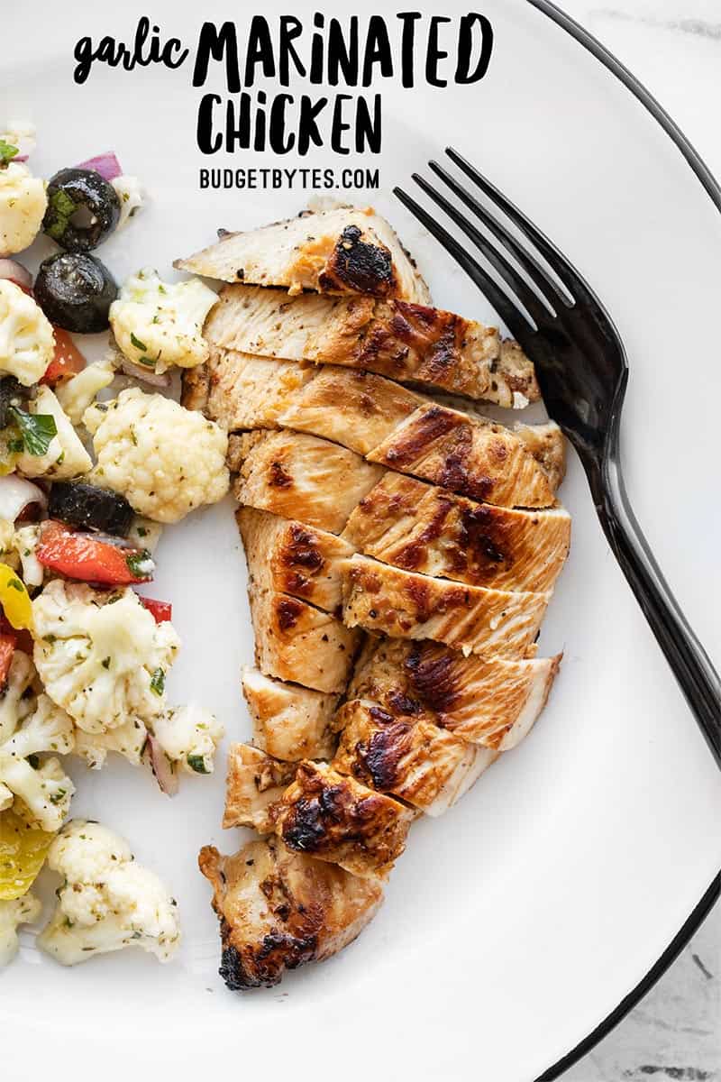 Garlic marinated chicken on a plate with a fork, title text at the top.