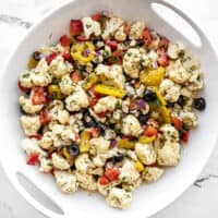 Overhead view of marinated cauliflower salad in a white serving bowl