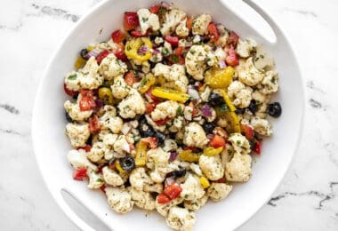 Overhead view of marinated cauliflower salad in a white serving bowl