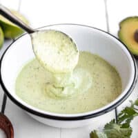 Creamy avocado dressing dripping off a spoon into a bowl