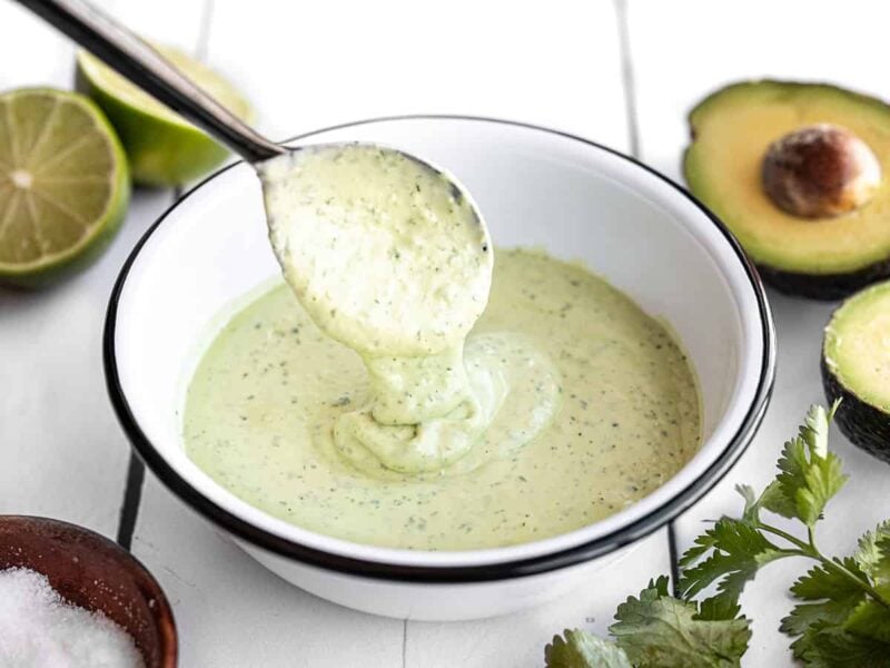 Creamy avocado dressing dripping off a spoon into a bowl