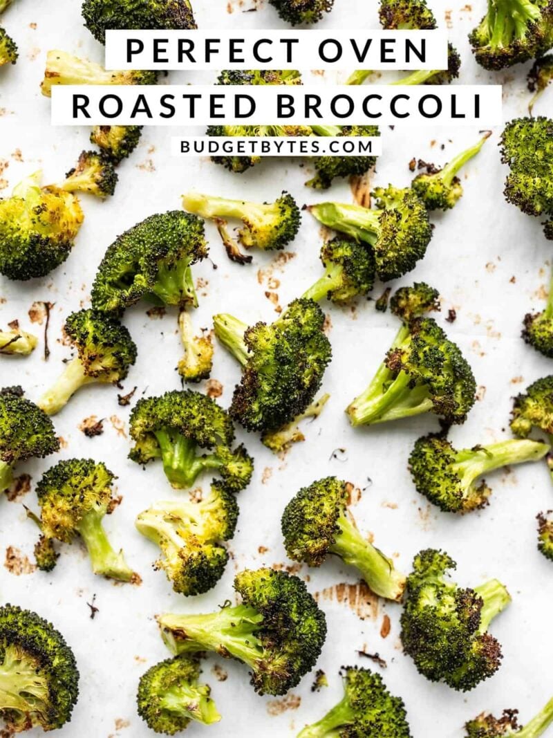 Close up of oven roasted broccoli on a sheet pan, title text at the top