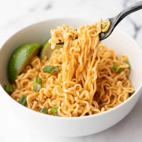 Ramen noodles being lifted from the bowl with a fork