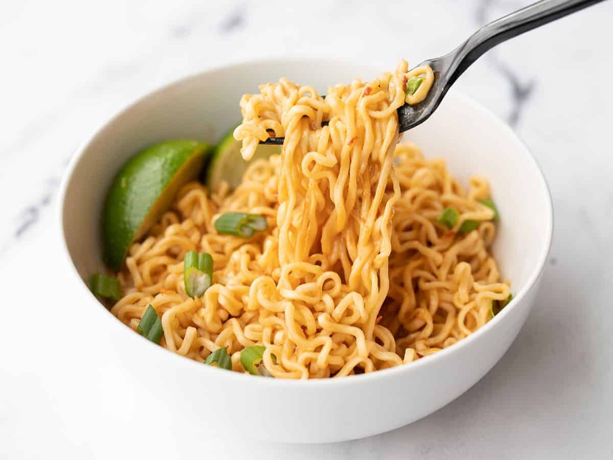 Ramen noodles being lifted from the bowl with a fork