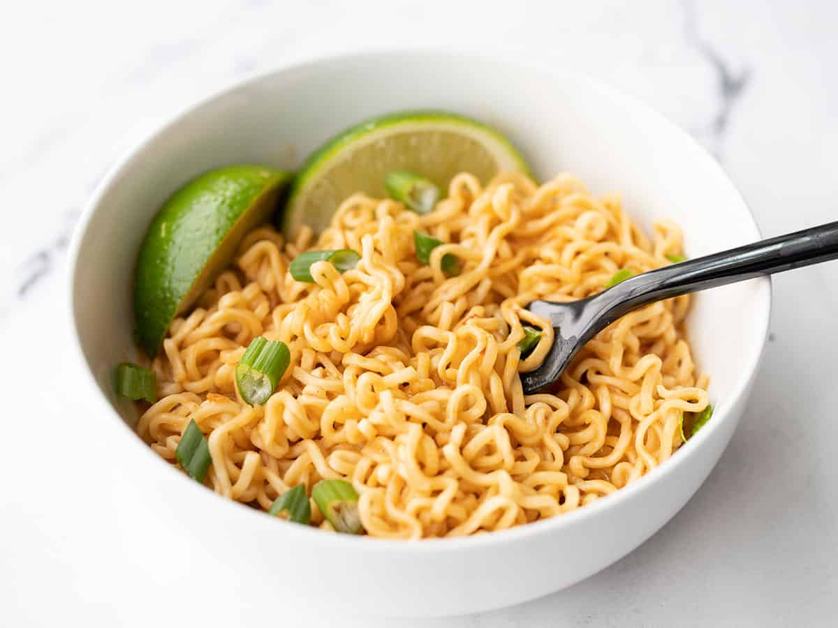 Front view of a bowl of spicy peanut butter ramen noodles with a fork
