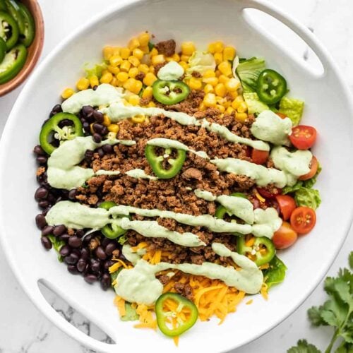 overhead view of turkey taco salad drizzled with creamy avocado dressing